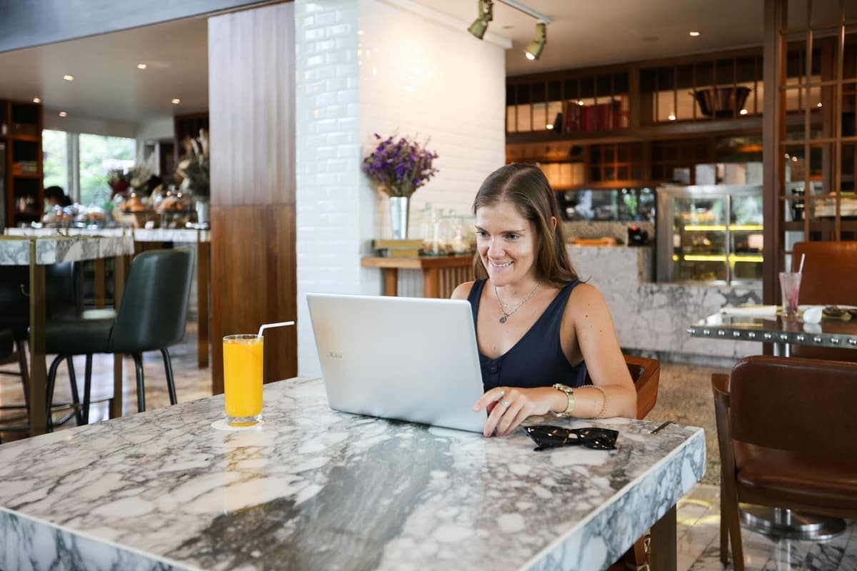 Creator working on laptop in a cafe
